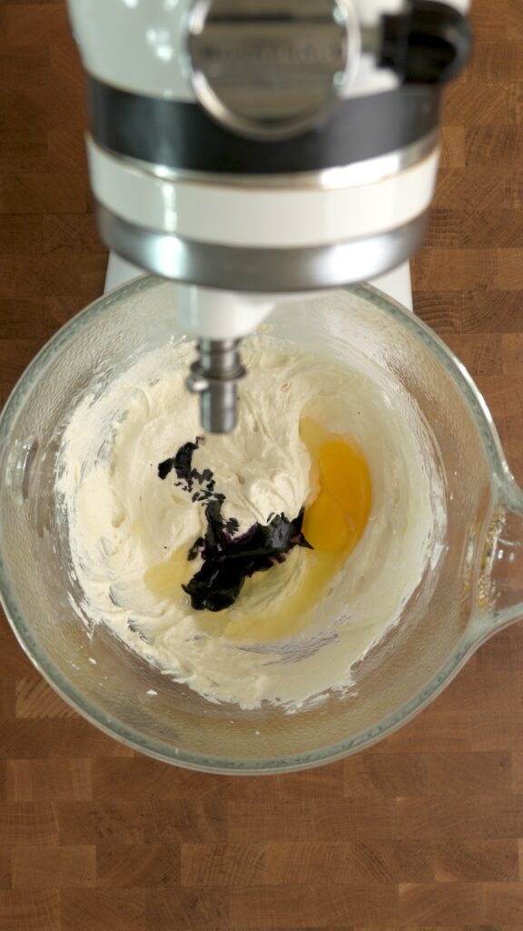 Adding ube extract and egg to the mixture